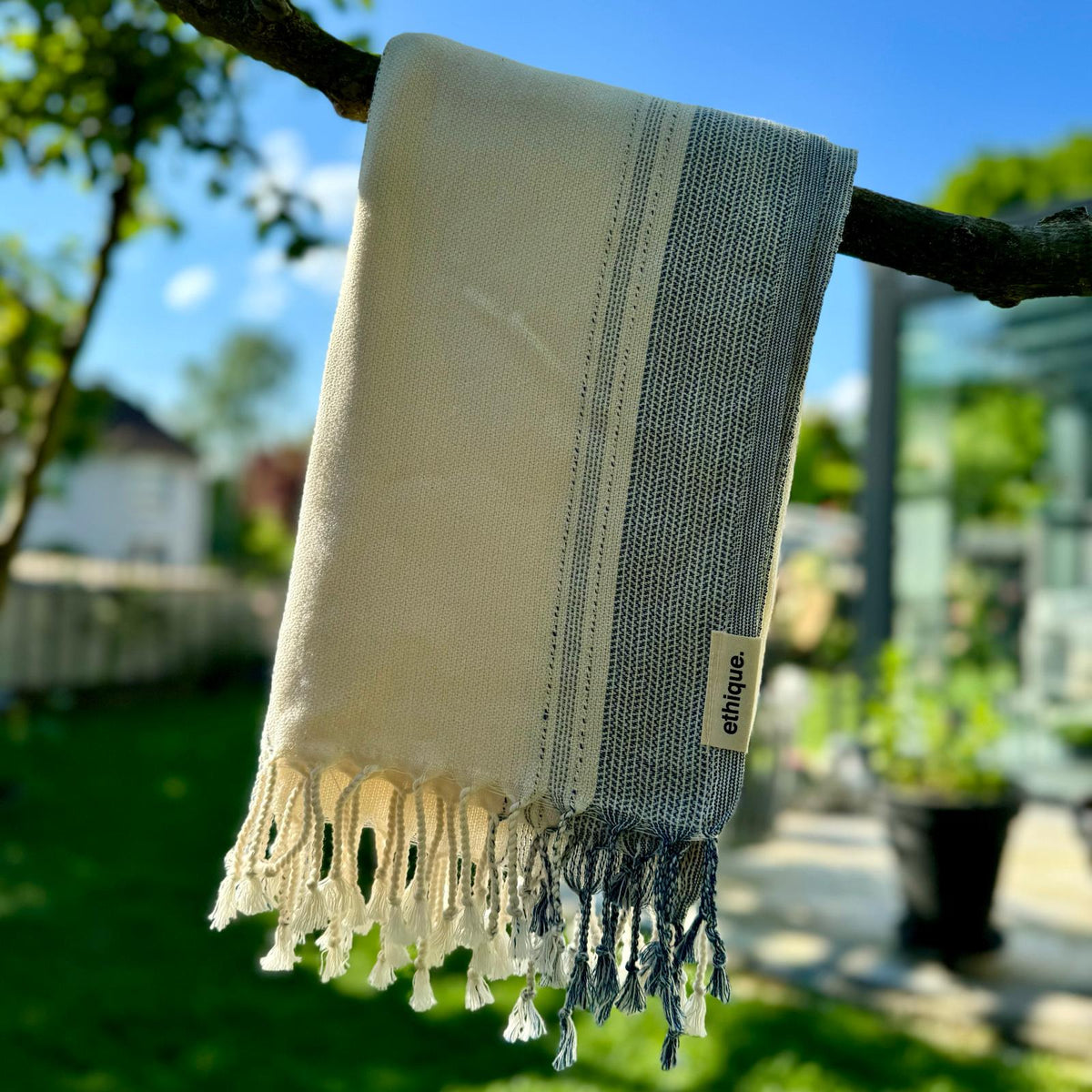 Großes hellbeige-weiß-blau gestreiftes Handtuch, perfekt als luxuriöses Badetuch, für Wellness oder als funktionales Strandaccessoire.